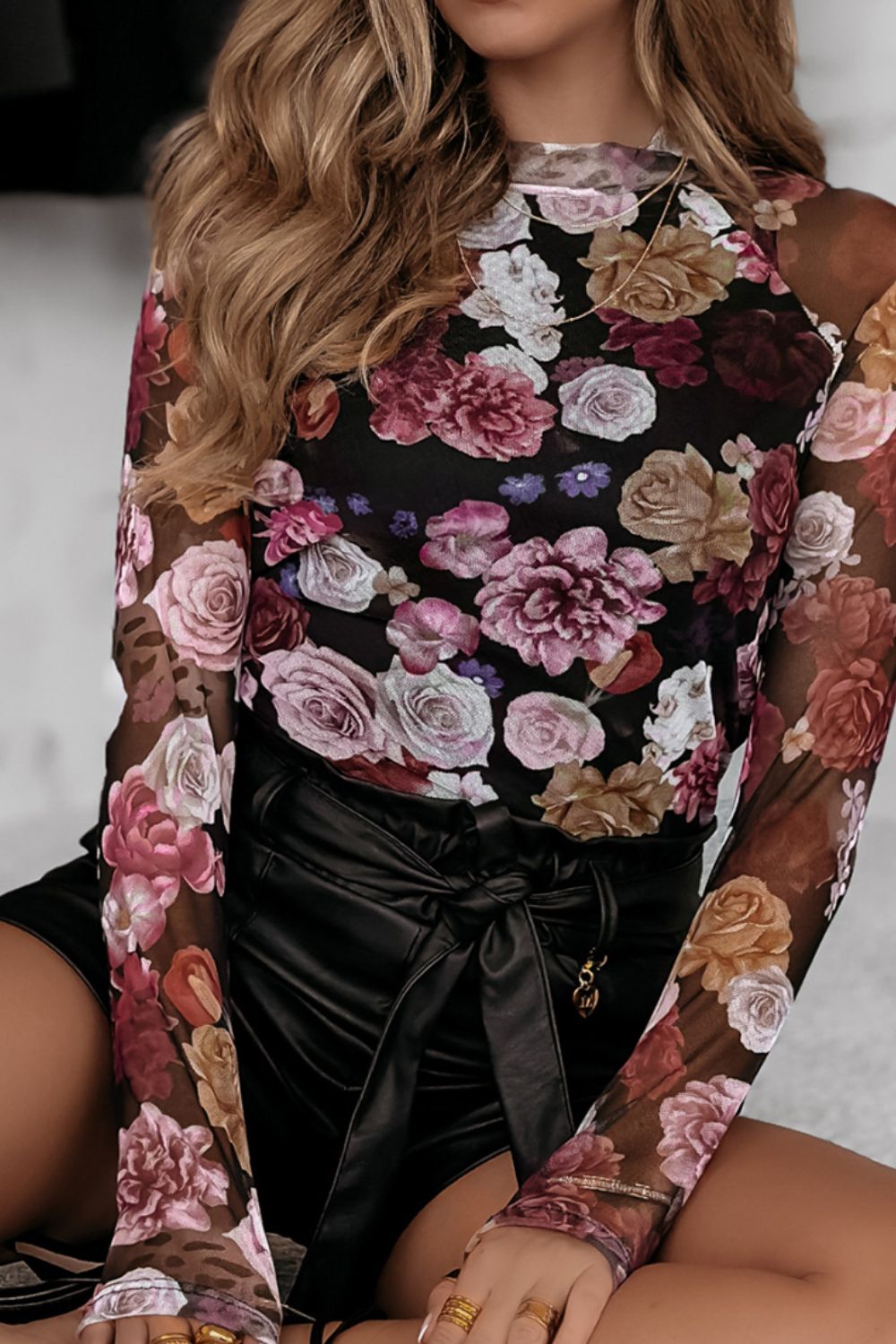 Black mesh blouse with a romantic floral print, long sleeves, and mock neck.