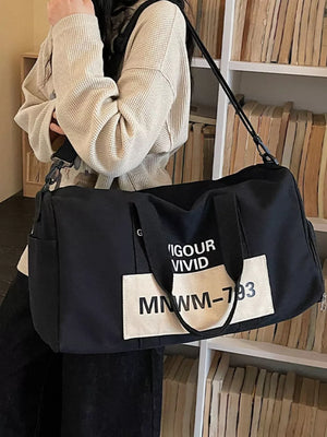 Black nylon travel bag with white graphic text detail and adjustable strap