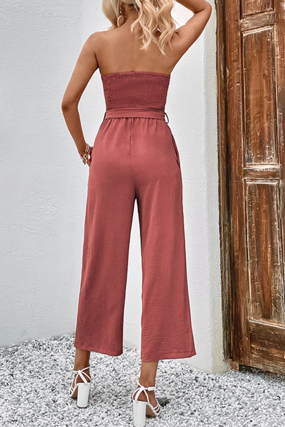 Smocked bodice wide-leg jumpsuit in watermelon pink with tie belt and cropped length.