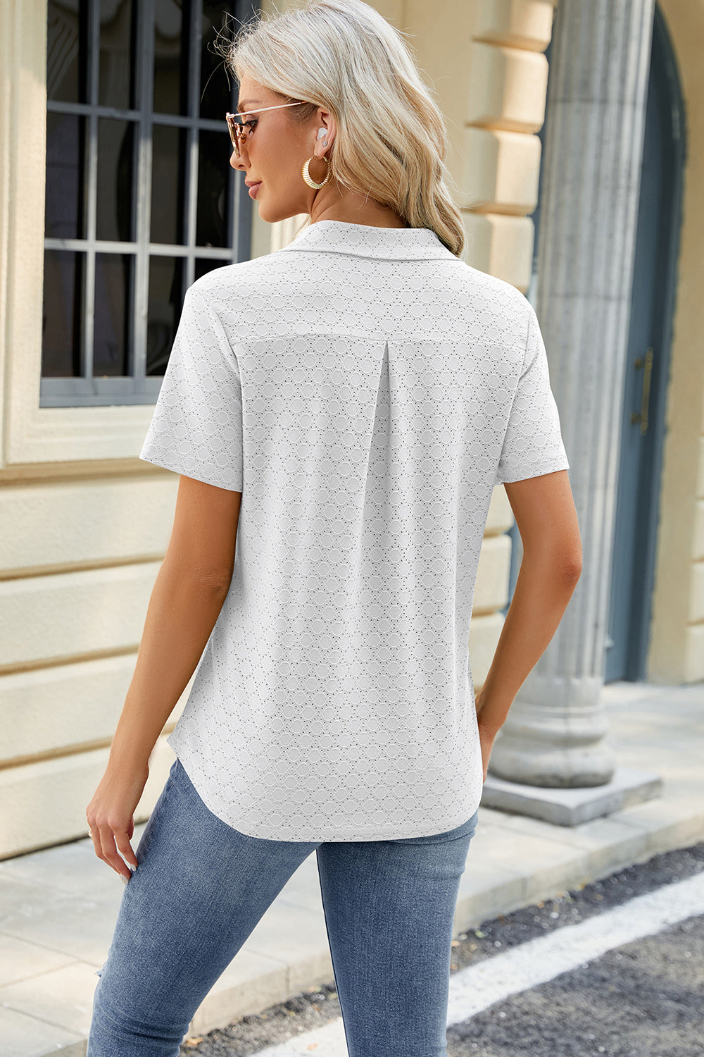 White textured polo shirt with V-neck detail and short sleeves.