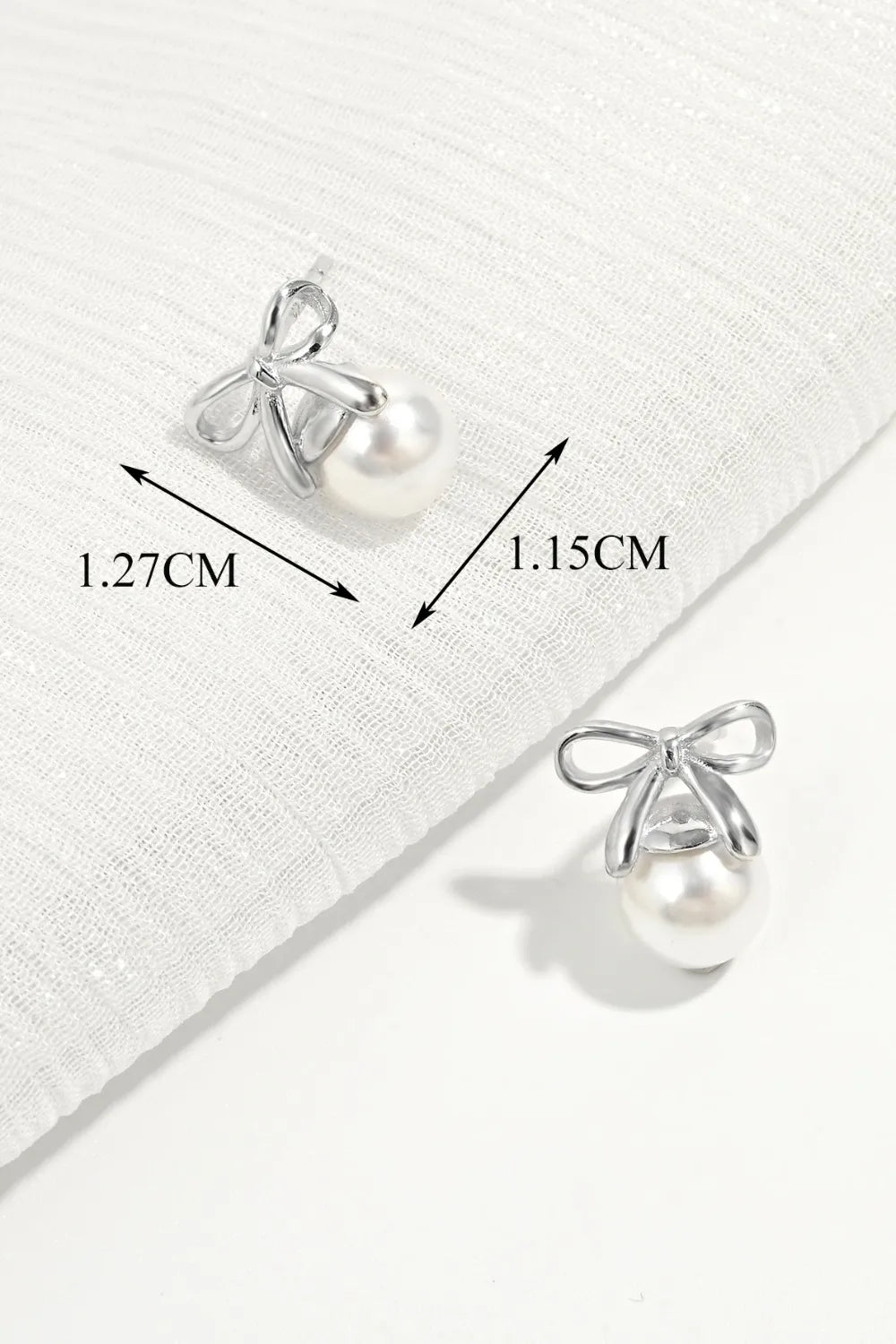 Silver bow pearl drop earrings with detailed measurements shown.