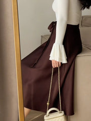 Burgundy satin midi skirt with tie waist detail.