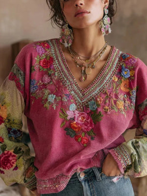 Embroidered deep rose V-neck blouse with floral print sleeves and neckline detail.