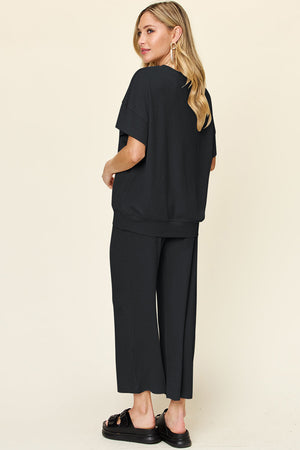 Black waffle knit lounge set with short sleeve top and wide leg pants.