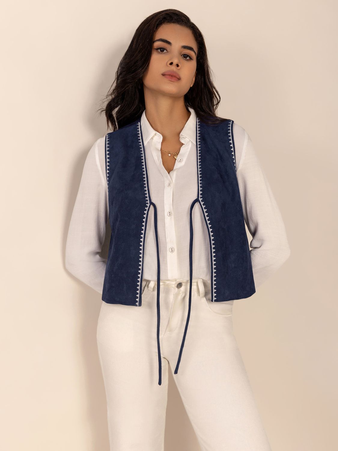 Dark blue suede-effect vest with white stitch trim and tie front.