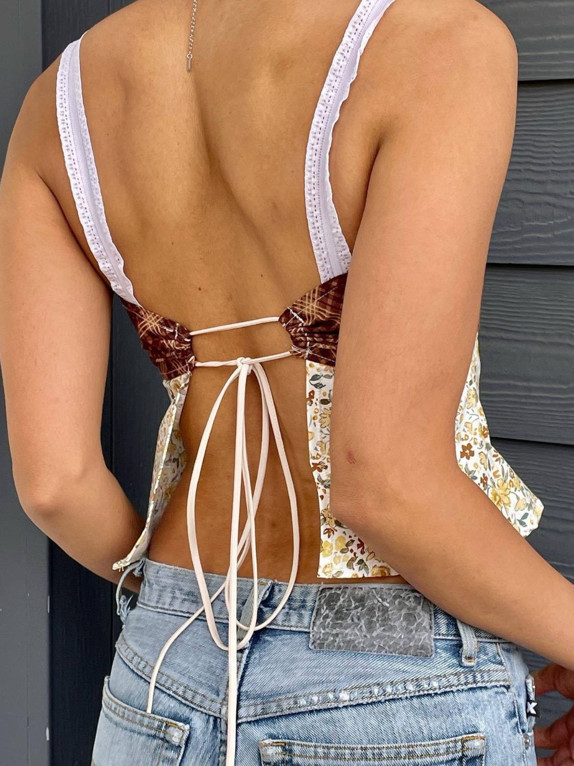 Mixed print corset cami with lace straps and back tie detail, styled with jeans.