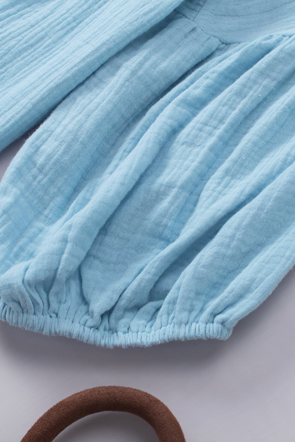 Textured gauze blouse in Pastel Blue with gathered sleeves and elasticized hem.