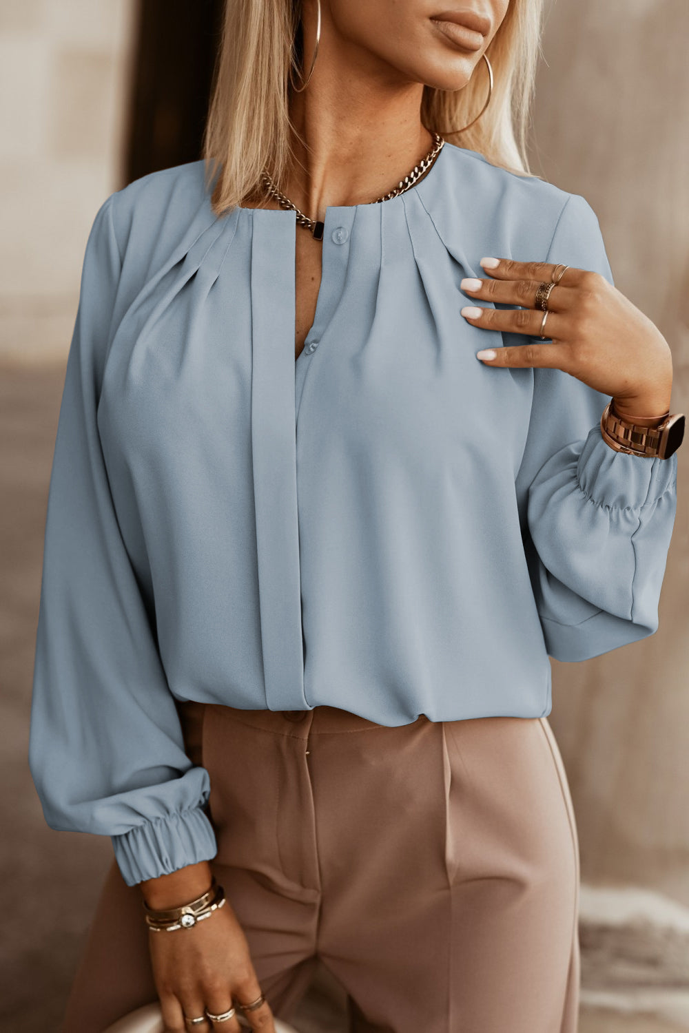 Misty Blue pleated yoke blouse with button detail and cinched cuffs.