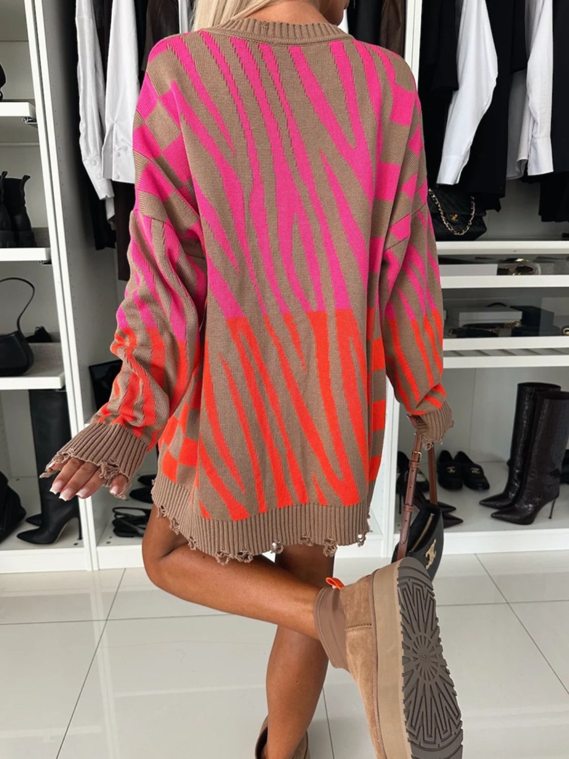 Distressed zebra-stripe knit tunic sweater in brown with pink and orange stripes, featuring a crew neck and distressed hem.