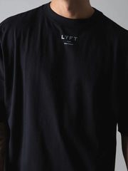 Black oversized graphic tee with silver text detail on chest.