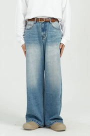 Wide-leg denim jeans in medium wash with pockets and a brown belt.