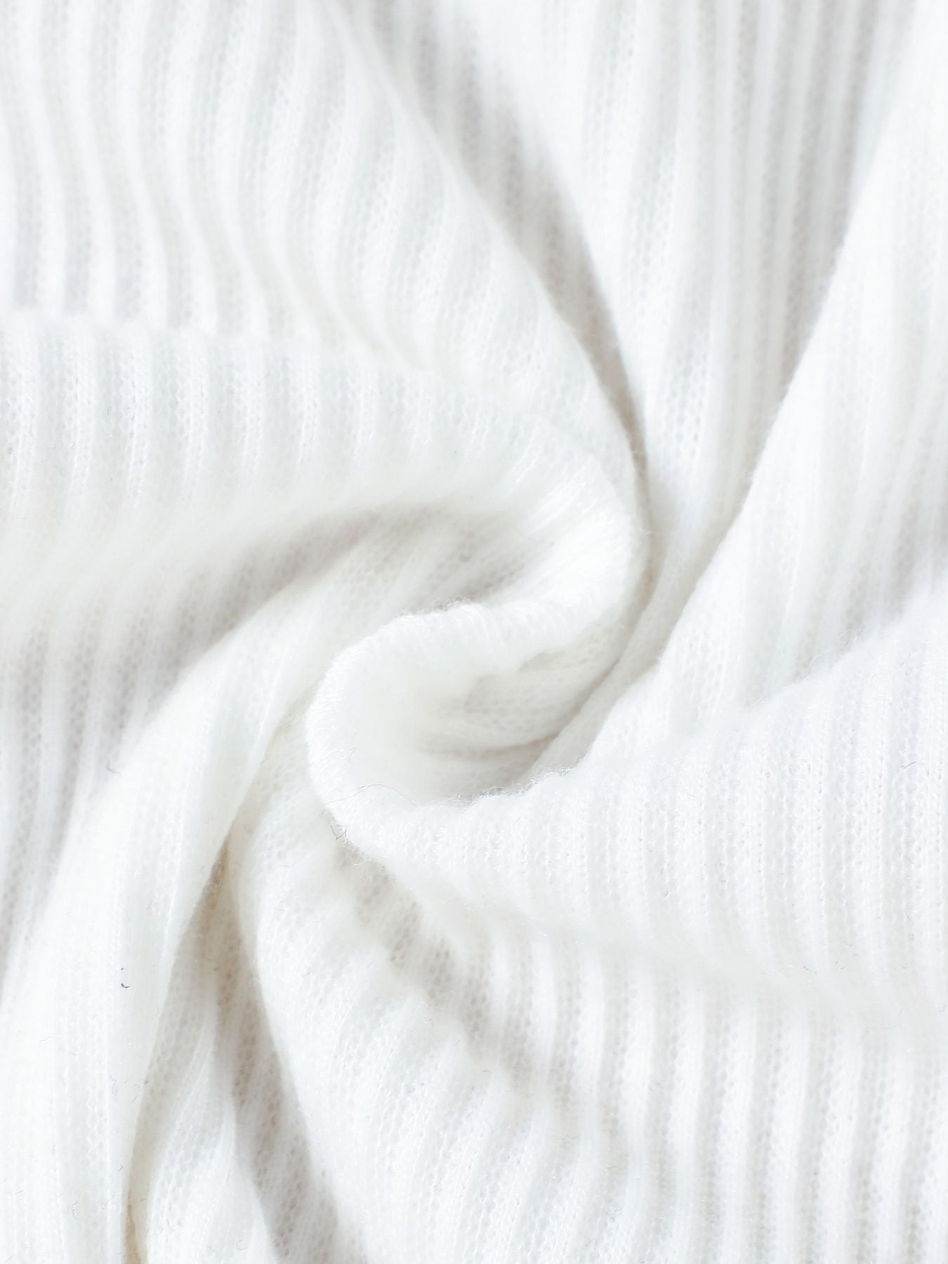 White ribbed knit fabric detail of a baby top and skirt set