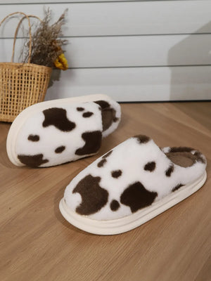 Cow print faux fur house slides in white and brown with a cream sole.