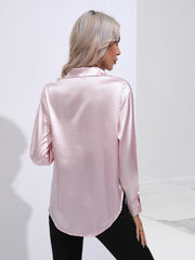 Blush pink satin tie-front blouse with buttoned cuffs and a collared neckline.