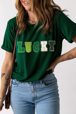 Dark green t-shirt with rolled sleeves and a gold-trimmed "LUCKY" appliqué across the chest.