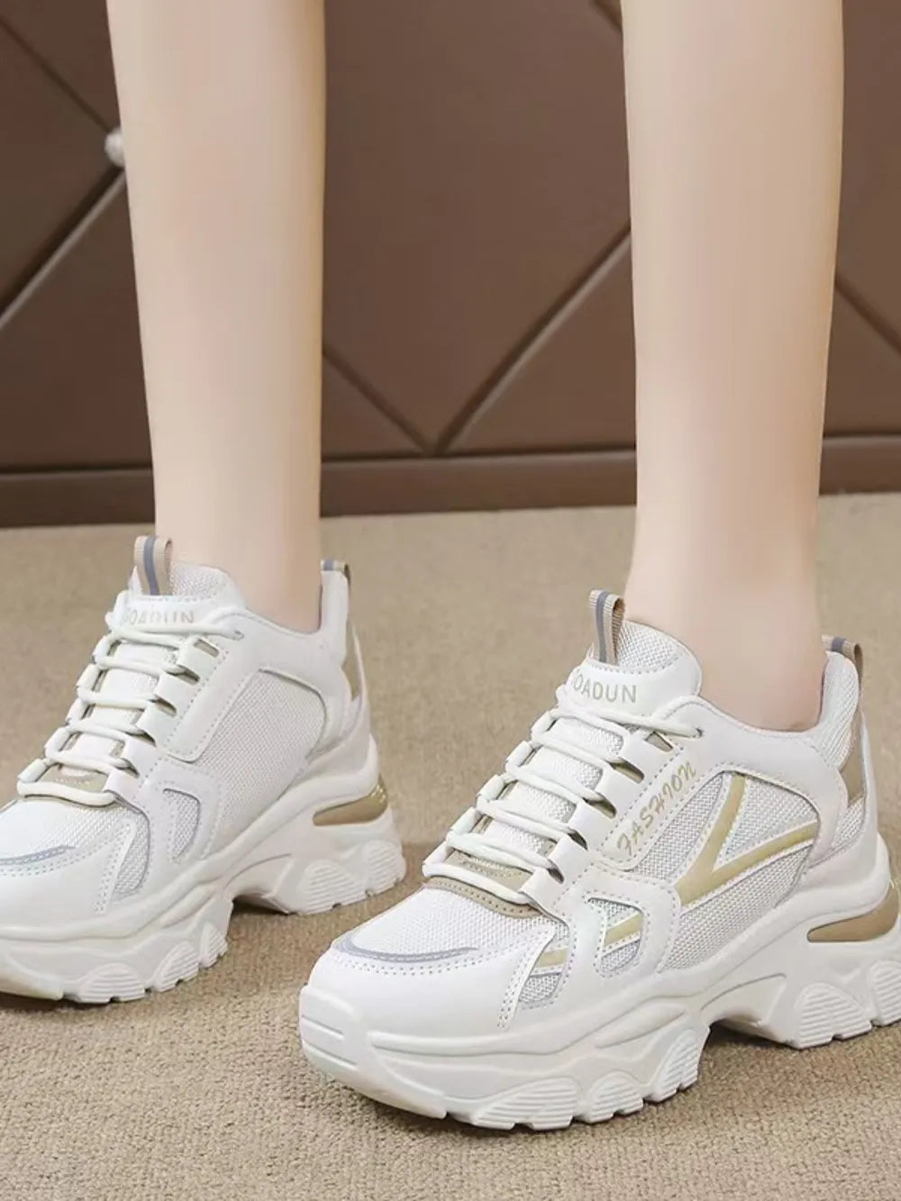 White textured mesh and leather chunky sneakers with gold accents.