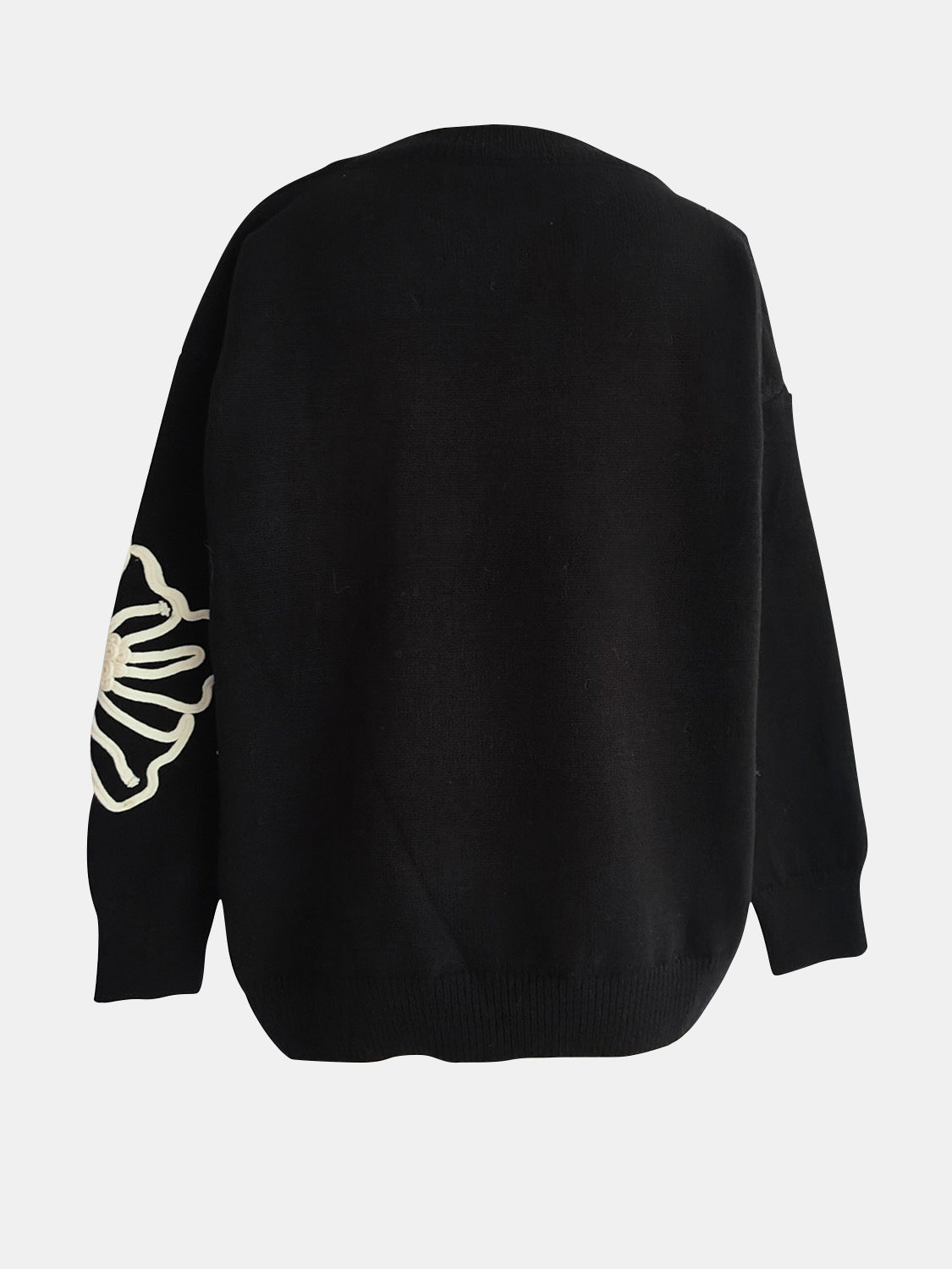 Black long sleeve sweater with embroidered blossom detail on sleeve