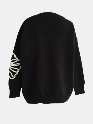 Black long sleeve sweater with embroidered blossom detail on sleeve