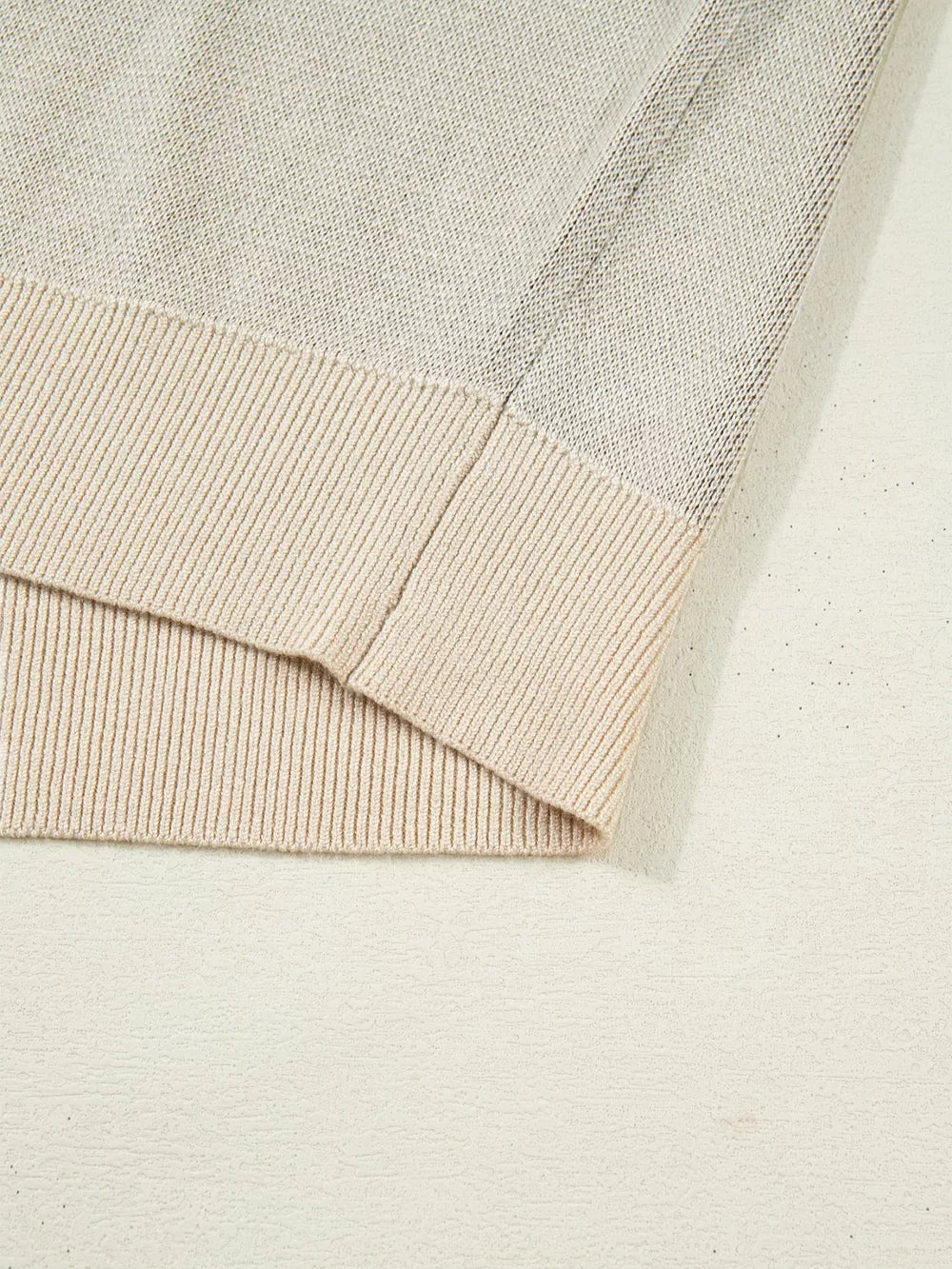 Sleeveless sweater vest in beige acrylic with ribbed trim and knit texture detail.