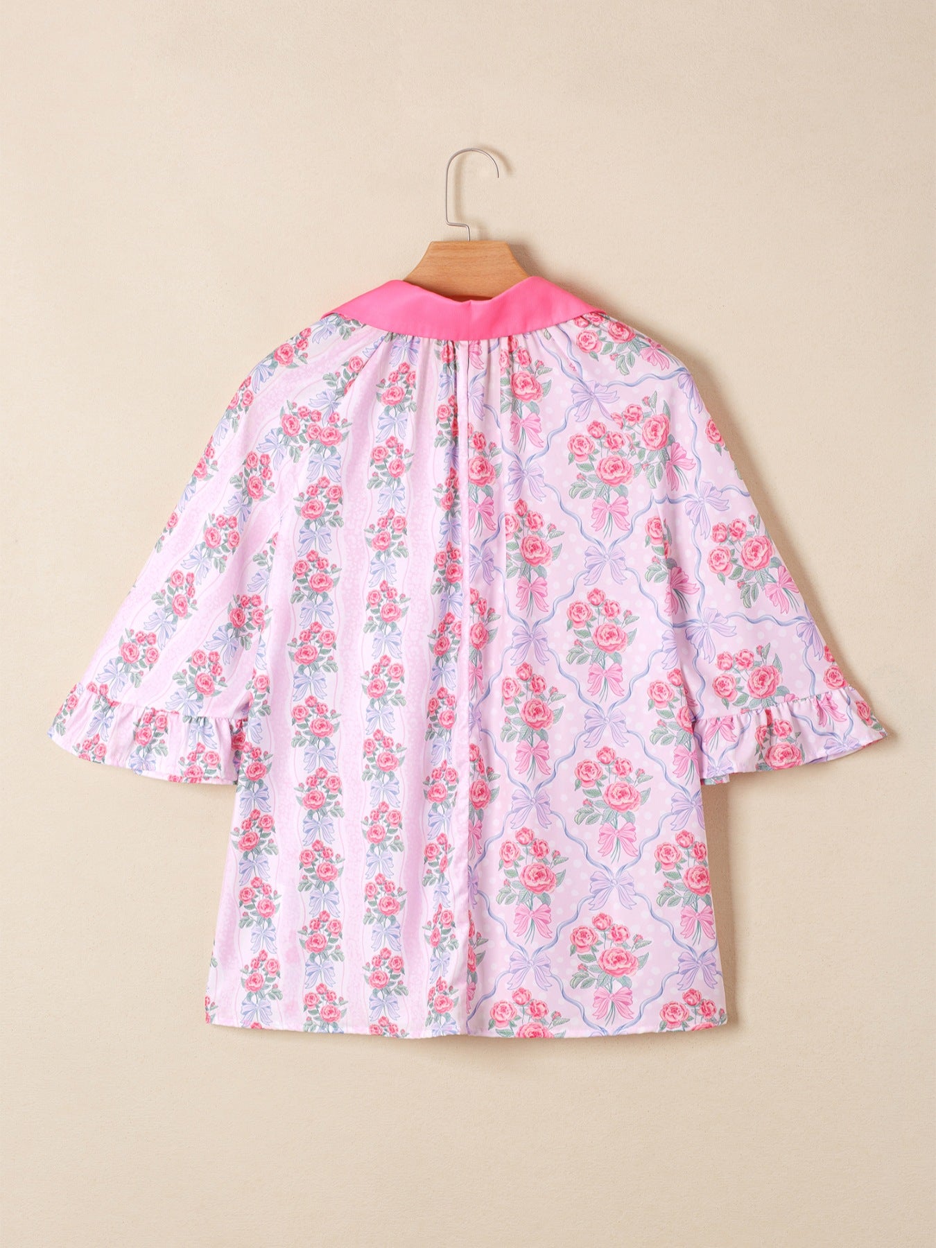 Pink floral and bow print maternity shirt with ruffled sleeves and pink collar.