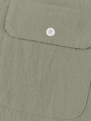 Military green cotton henley shirt with button-flap chest pocket detail.