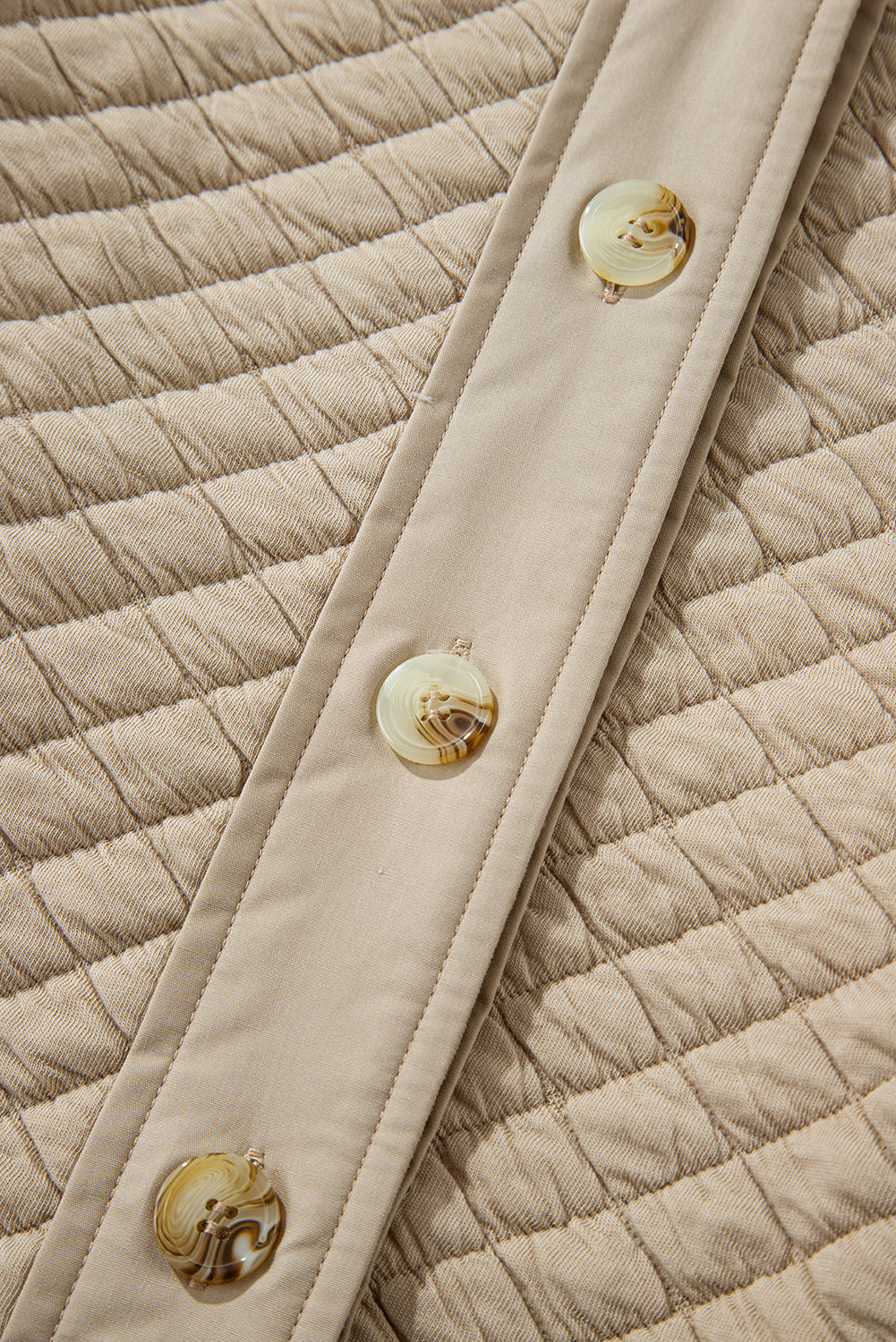 Beige diamond quilted oversized button-up jacket with marbled buttons.