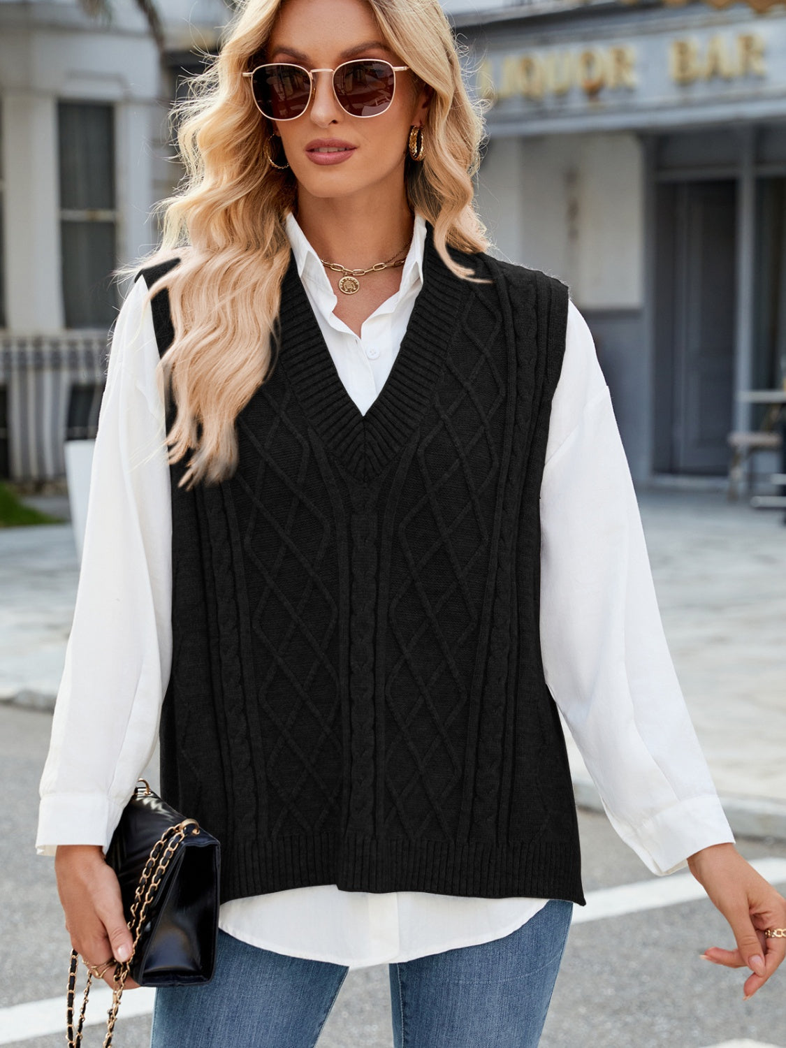 Black cable knit v-neck sweater vest with diamond pattern detail.
