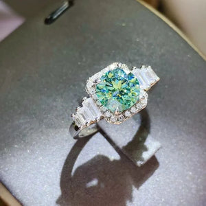 Emerald halo ring with baguette accents in silver.