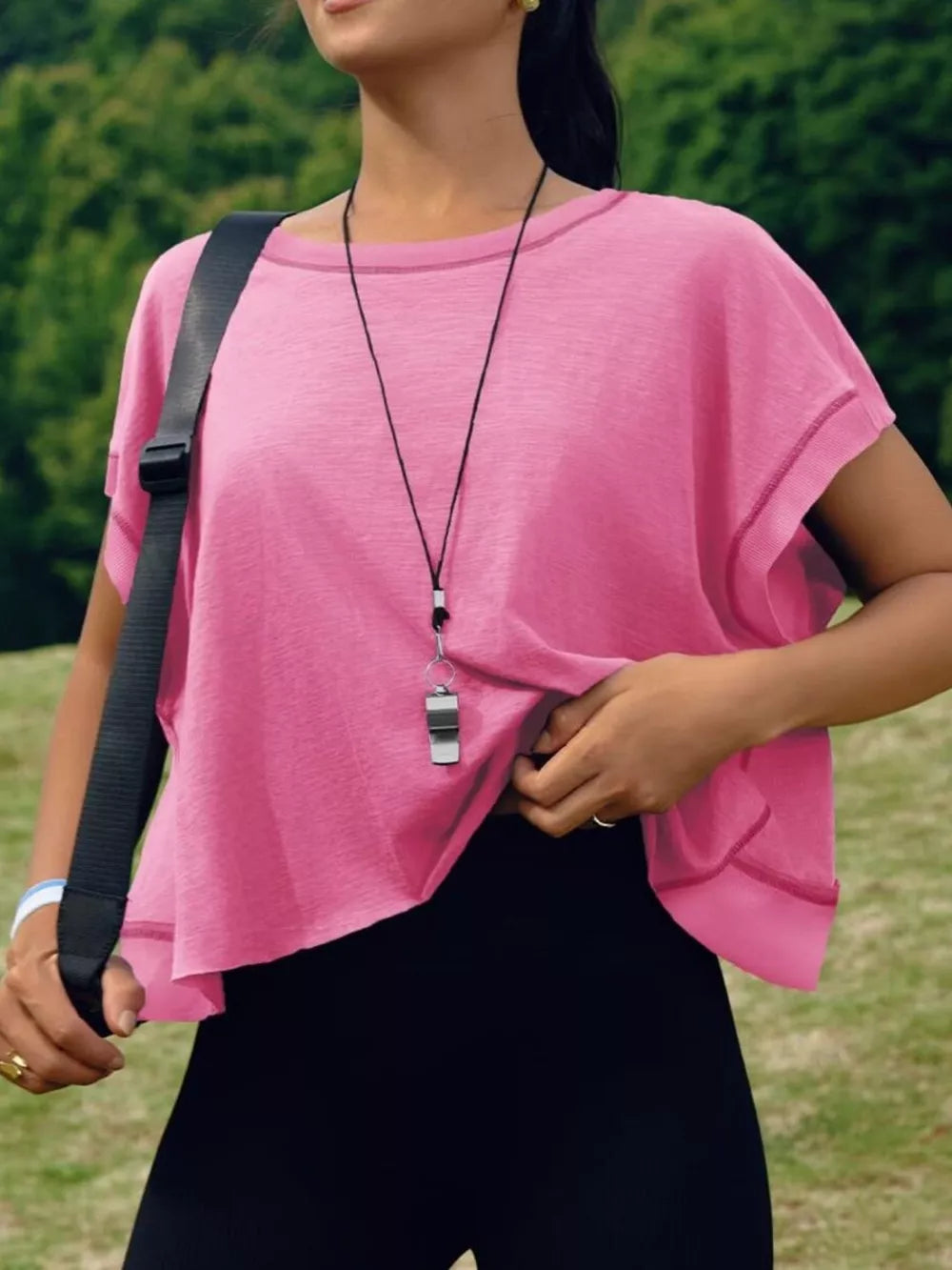 Pink t-shirt with exposed seams and contrast stitching, crew neck, short sleeves, and a cutout back detail.