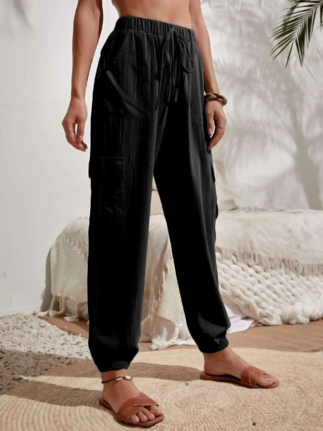 Black textured cargo lounge trousers with drawstring waist and side pockets.