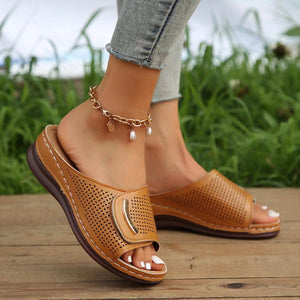 Perforated wedge sandals in tan with gold buckle detail and white stitching.