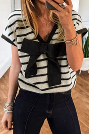 Chic black and white striped knit top with a large black bow detail and short sleeves.