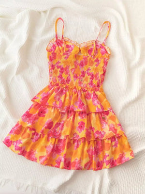 Floral cutout mini dress with smocked bodice and tiered skirt in orange and pink.