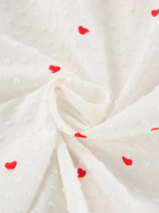White cotton pajama fabric with red heart print and textured dots