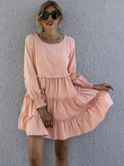 Apricot ruffled mini dress with long sleeves and tiered skirt.
