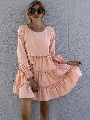 Apricot ruffled mini dress with long sleeves and tiered skirt.