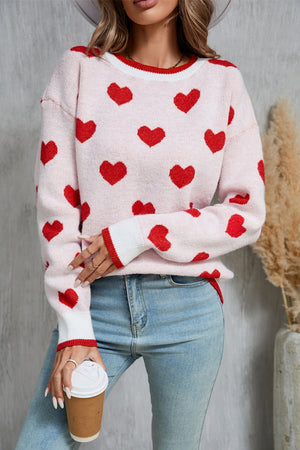 Pink crewneck sweater with red hearts pattern, ribbed cuffs and neckline.