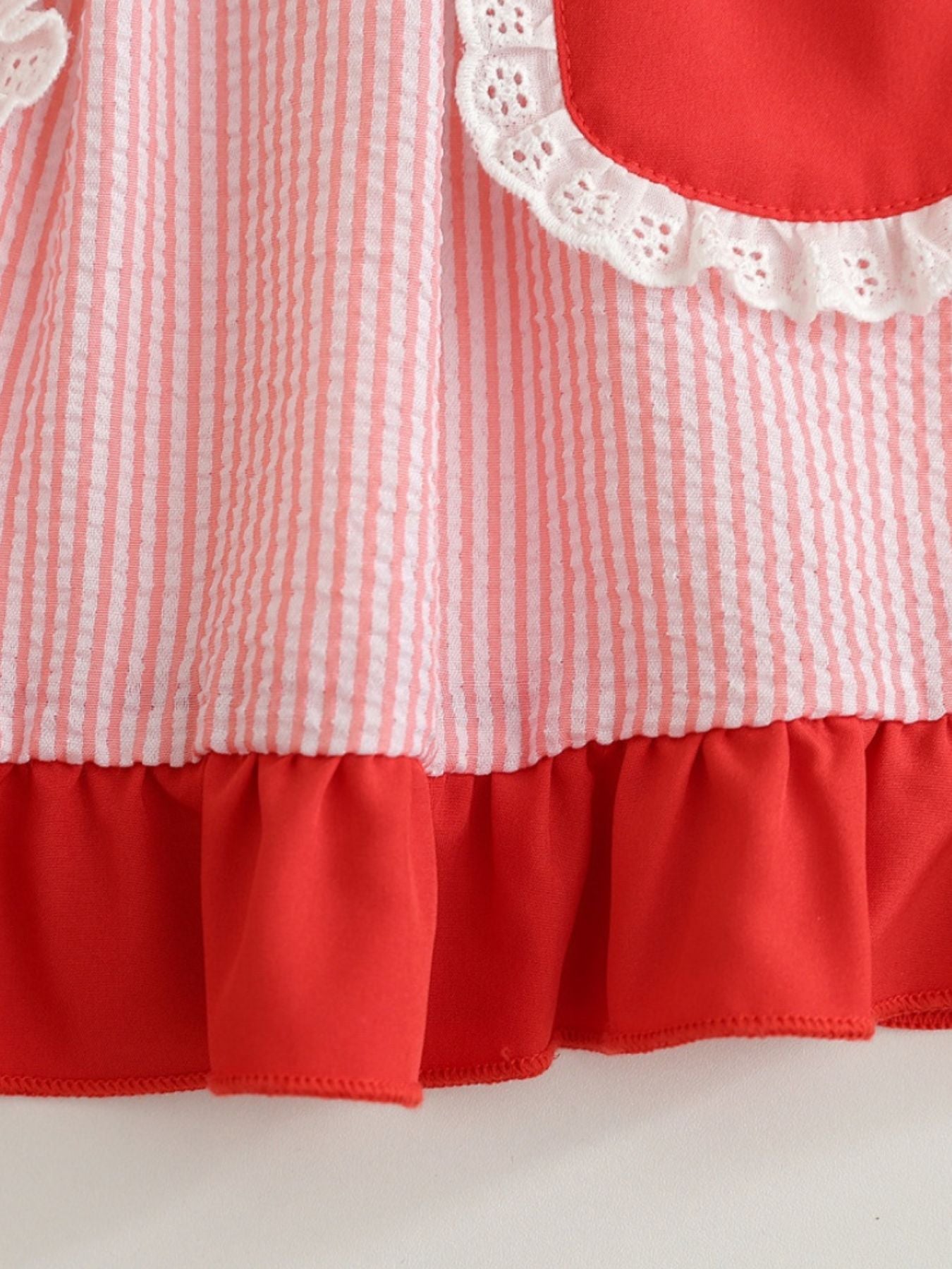 Baby dress with pink and white stripes, red ruffle hem, and white eyelet trim.