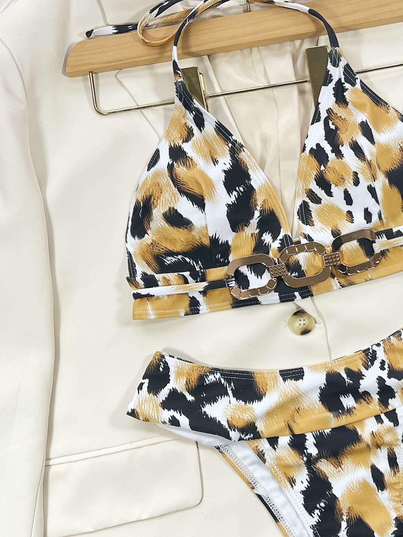 Leopard print bikini with gold chain detail on white blazer