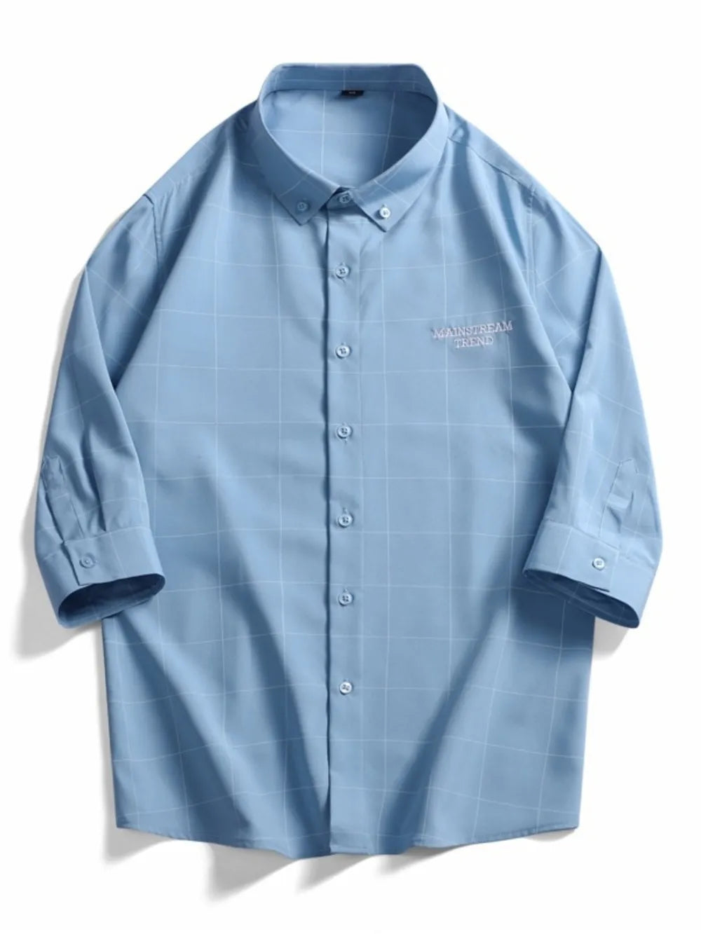 Blue oversized plaid button-down shirt with embroidered text detail.