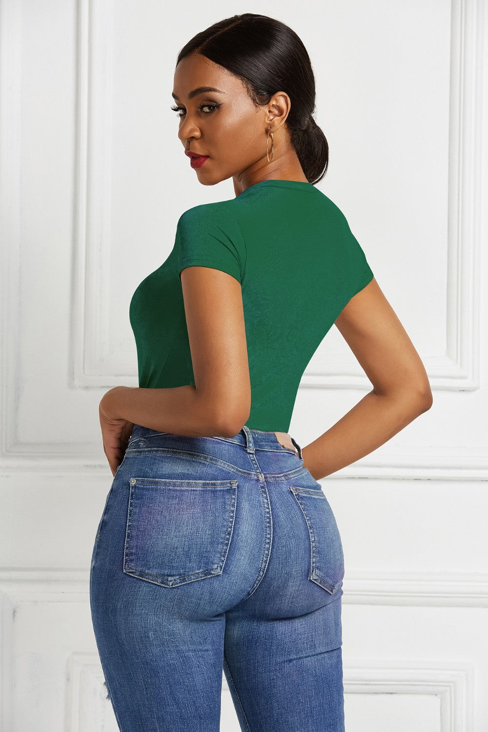 Dark green crew neck bodysuit with short sleeves, styled with blue jeans.