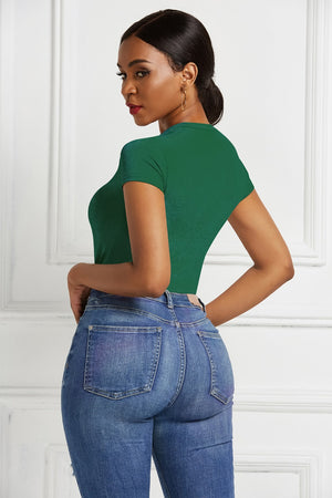 Dark green crew neck bodysuit with short sleeves, styled with blue jeans.