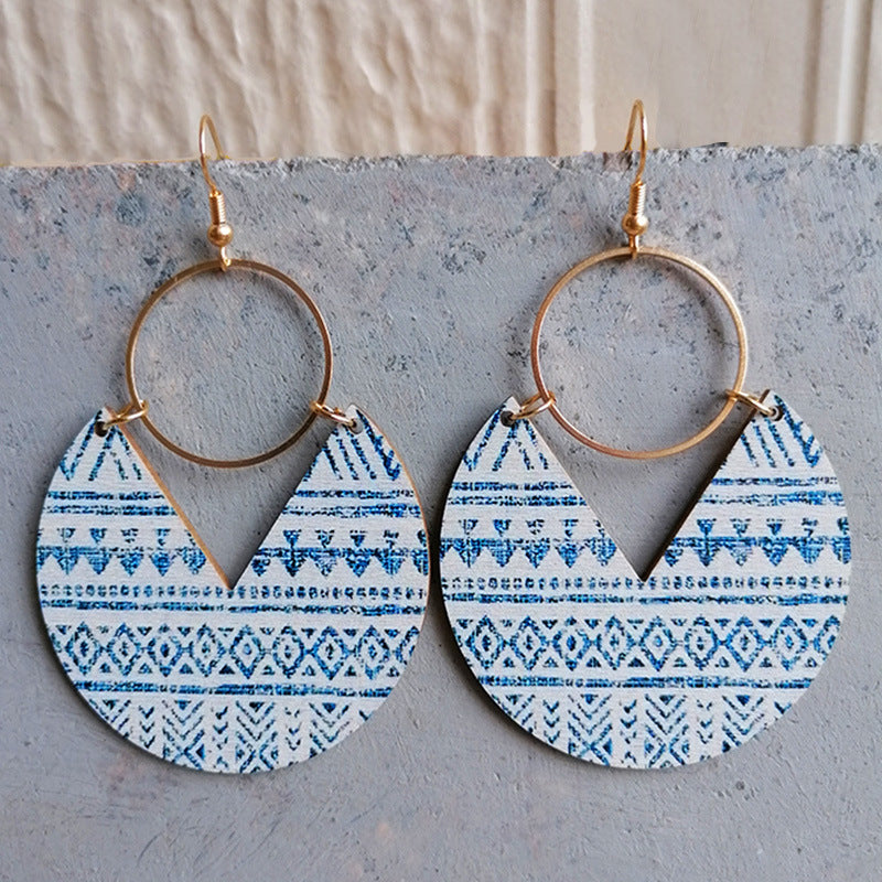 Geometric wood drop earrings with blue tribal pattern and gold hoops