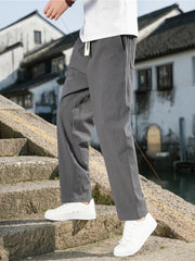 Men's dark gray drawstring sweatpants with pockets, relaxed fit, and white drawstring detail.