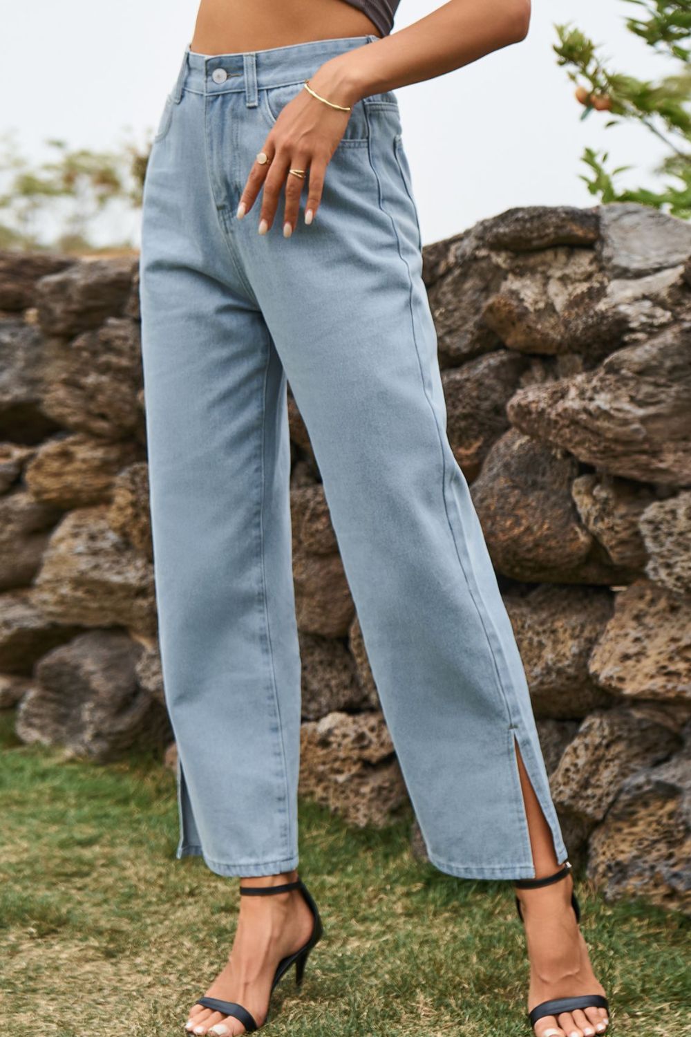 Light wash denim jeans with split hems and straight legs.
