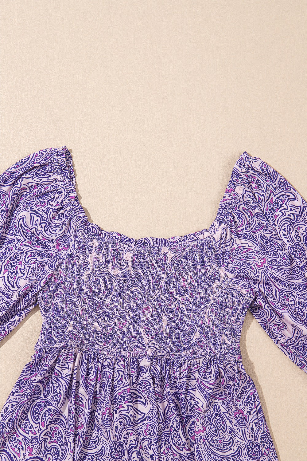 Paisley print smocked bodice blouse in lavender with square neckline and puff sleeves.