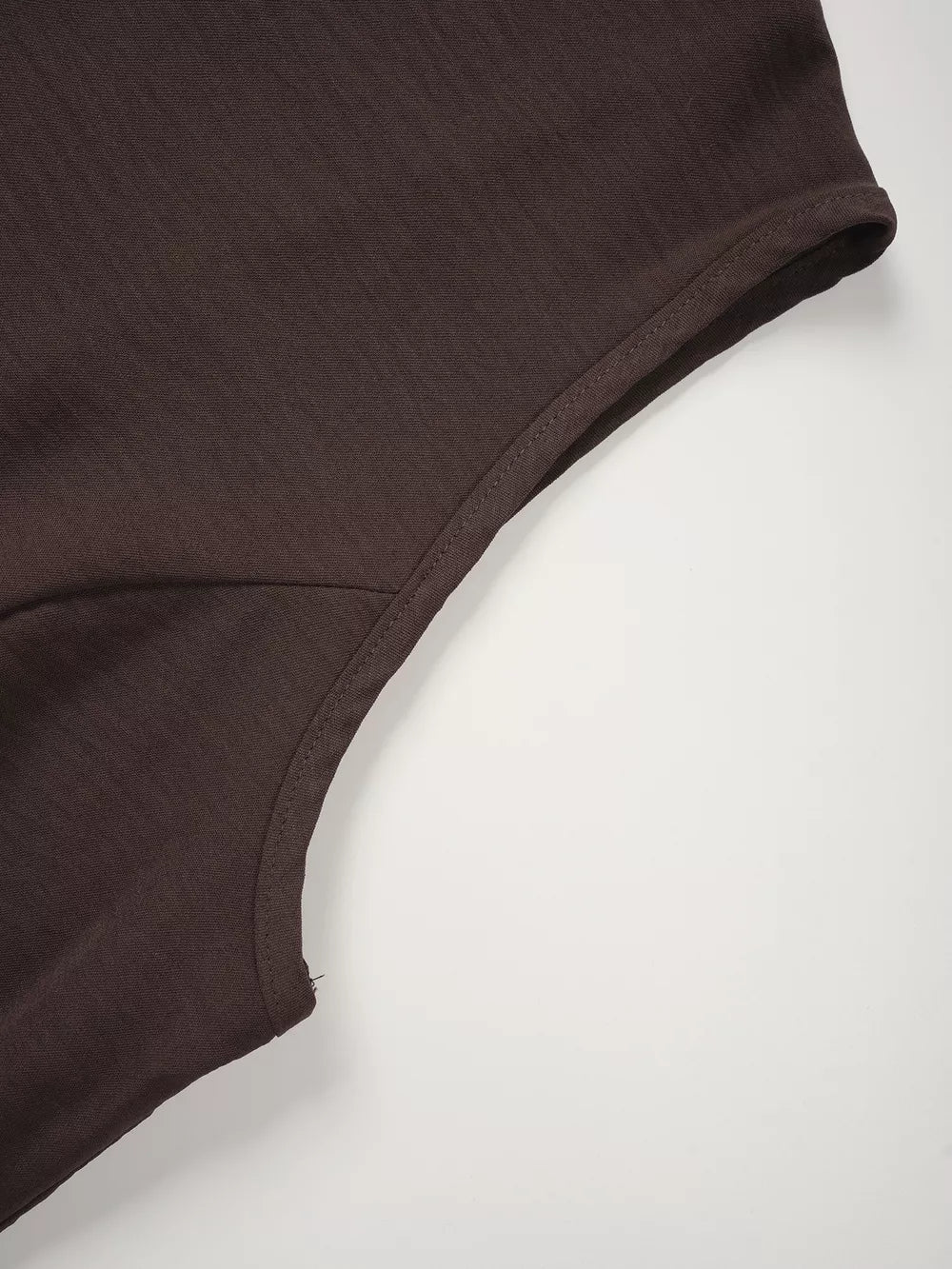 Chocolate cropped vest detail showing seam and fabric texture.