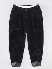Black corduroy pleated pants with elastic waistband and cuffed hem