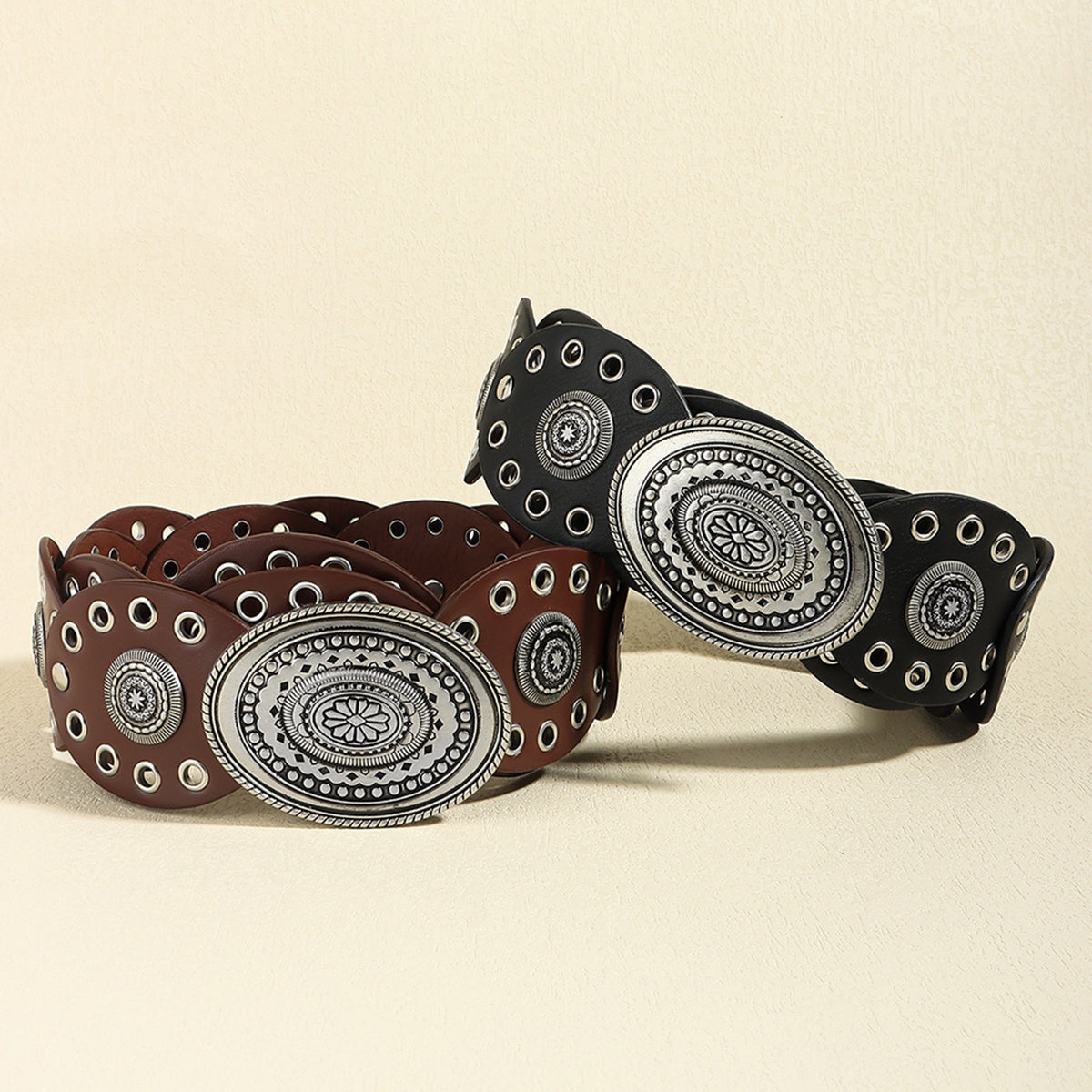 Western belt with eyelet details and oval antique silver buckle in dark brown and black.