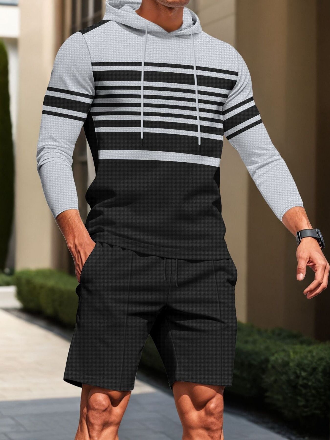 Men's grey and black striped hoodie with drawstring and matching textured shorts.